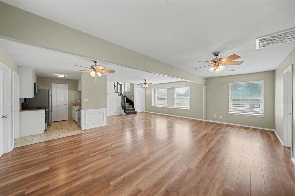 6925 Calender Road, Unit A Arlington, TX 76001 - Photo 11 of 19 a view of an empty room with wooden floor and a kitchen