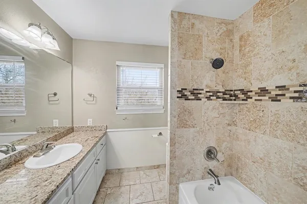 a bathroom with a tub sink and mirror