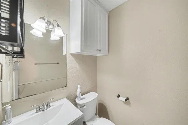 a bathroom with a sink mirror and toilet