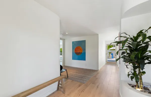 a kitchen with a sink a refrigerator and wooden floor