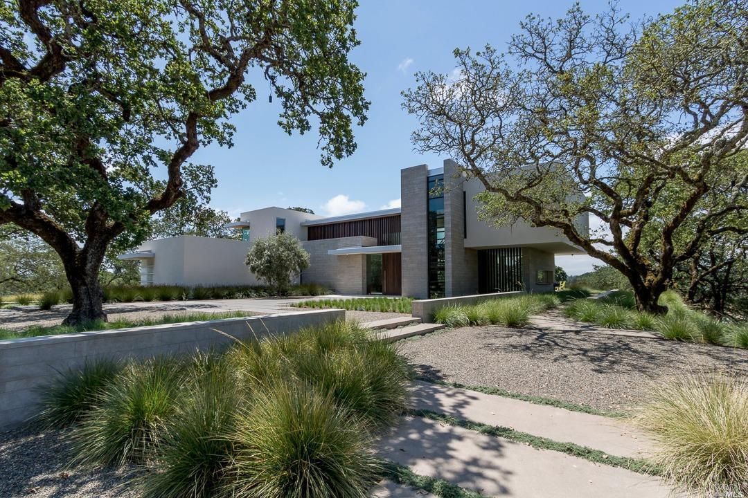a front view of a house with a yard and trees