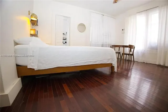 a bedroom with a bed and wooden floor