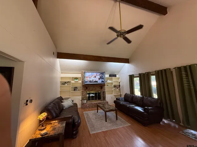 a living room with furniture a fireplace and a flat screen tv