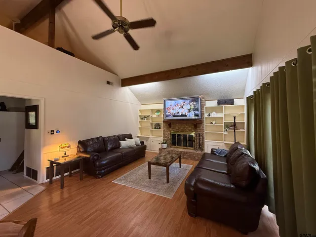 a living room with furniture a flat screen tv and a fireplace