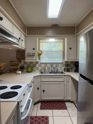 a kitchen with a sink window and cabinets