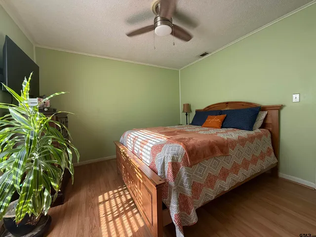 a bedroom with a bed and a potted plant