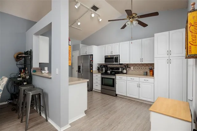 a kitchen with a refrigerator cabinets and wooden floor