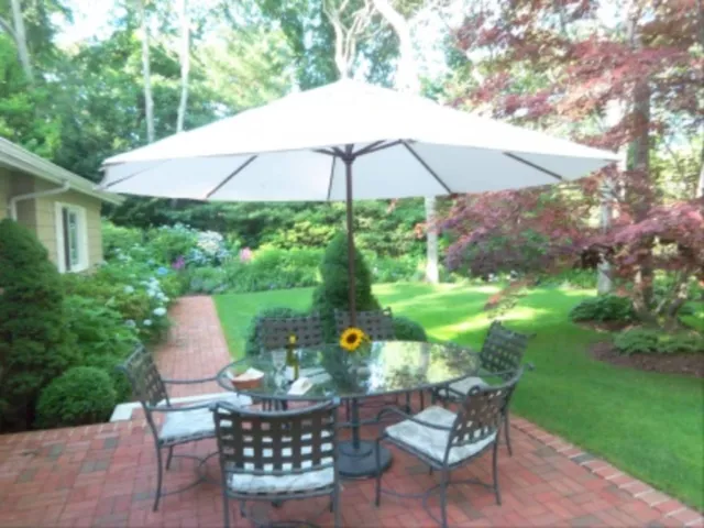 a backyard of a house with table and chairs