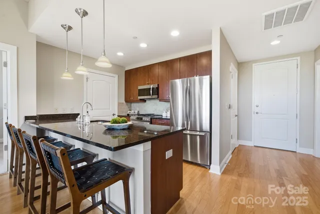 a kitchen with stainless steel appliances granite countertop a refrigerator a sink and a stove