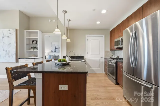 a kitchen with stainless steel appliances granite countertop a sink refrigerator and cabinets