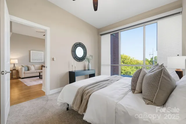 a bedroom with a bed mirror and window