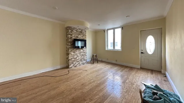 an empty room with wooden floor cabinet and windows