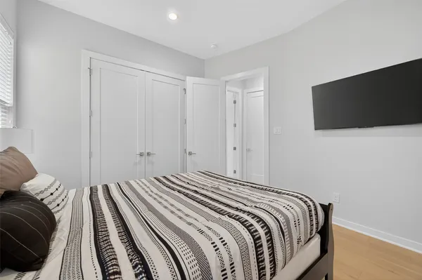 a bedroom with a bed and a painting on the wall