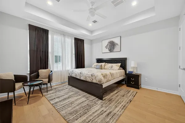 a bedroom with a bed a couch and a flat screen tv