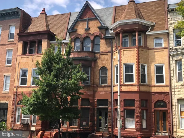 a front view of a residential apartment building with a yard
