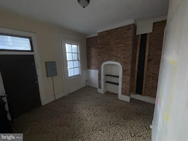 a view of an empty room with a fireplace and a window