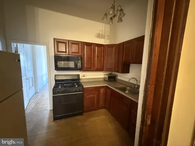 a kitchen with granite countertop a refrigerator stove and sink