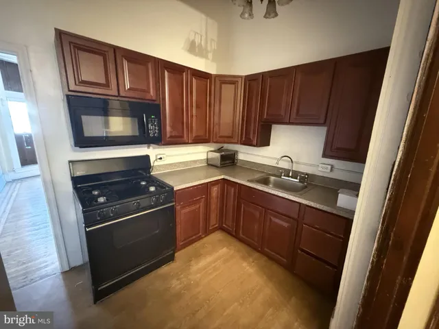 a kitchen with granite countertop wooden cabinets and stainless steel appliances