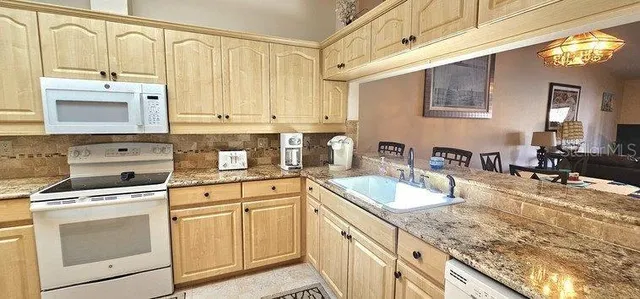 a view of a roof deck with couches chairs and wooden fence