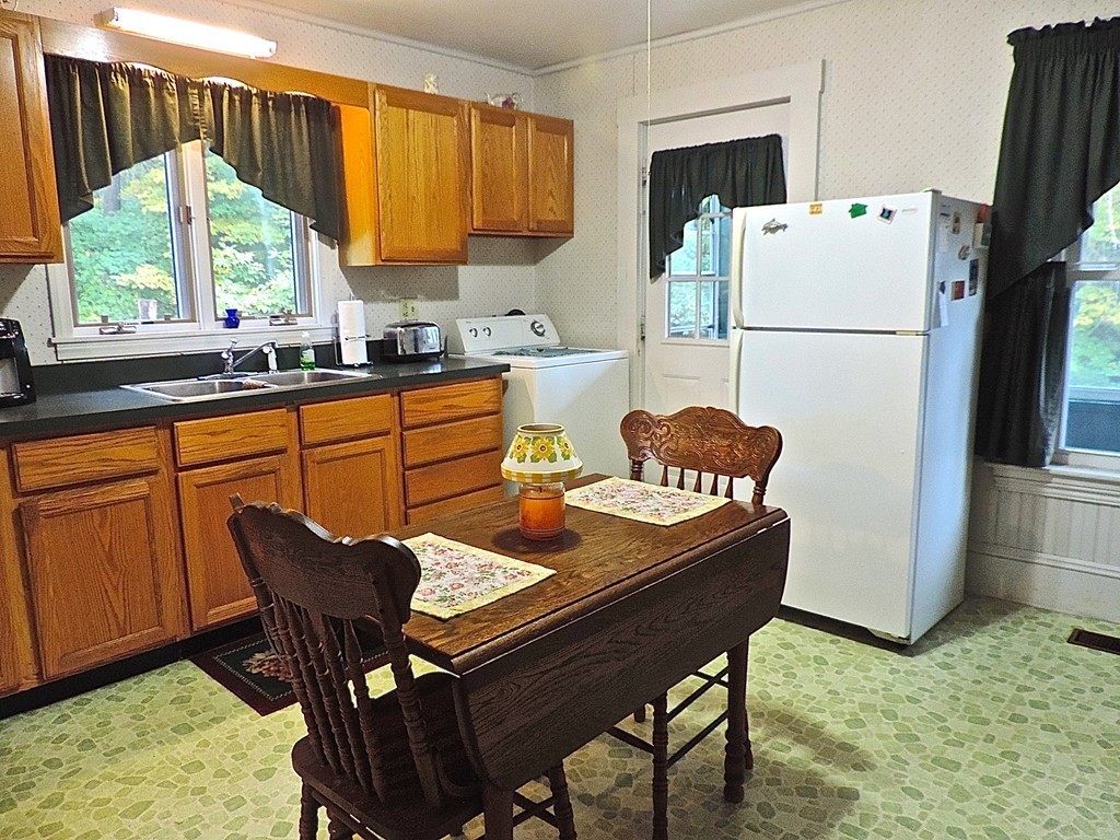 172 Call Road Colrain, MA 01340 - Photo 5 of 24 a kitchen with stainless steel appliances granite countertop a refrigerator a sink dishwasher and a dining table with wooden cabinet