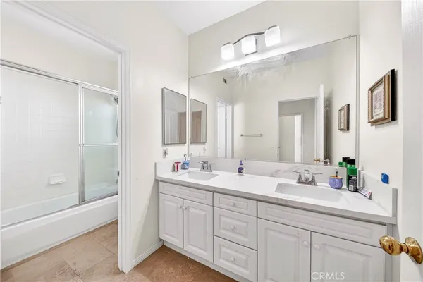 a bathroom with a double vanity sink mirror and shower
