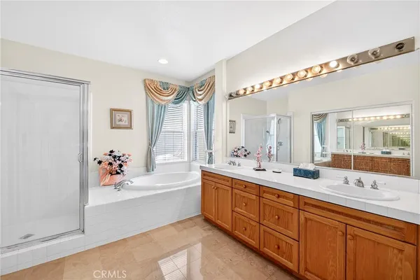 a spacious bathroom with a double vanity sink mirror and bathtub
