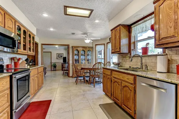 a kitchen with stainless steel appliances granite countertop a sink and cabinets