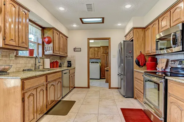 a kitchen with stainless steel appliances granite countertop a refrigerator and a stove