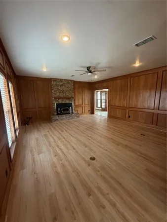 an empty room with wooden floor and fireplace