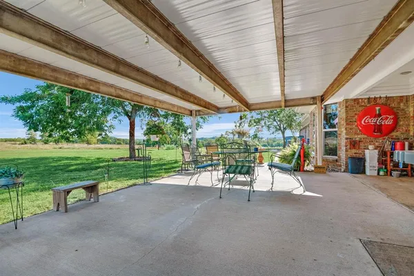 a view of a patio with a table chairs and a small yard