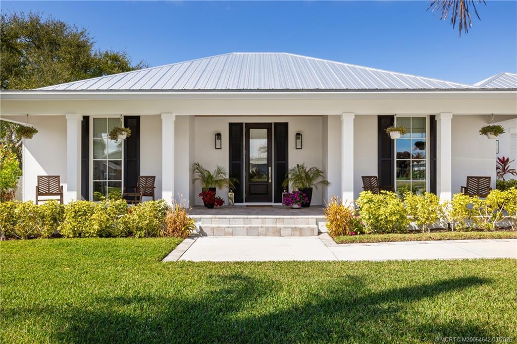 5169 Southeast Horseshoe Point Road Stuart, FL 34997 - Photo 2 of 54 a view of a house with potted plants and a table and chairs