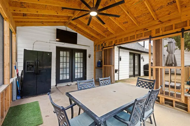 a patio with a table and chairs and potted plants