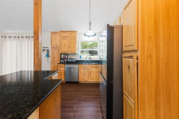 a kitchen with stainless steel appliances granite countertop a sink a stove and a refrigerator