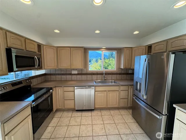 a kitchen with stainless steel appliances granite countertop a refrigerator and a sink