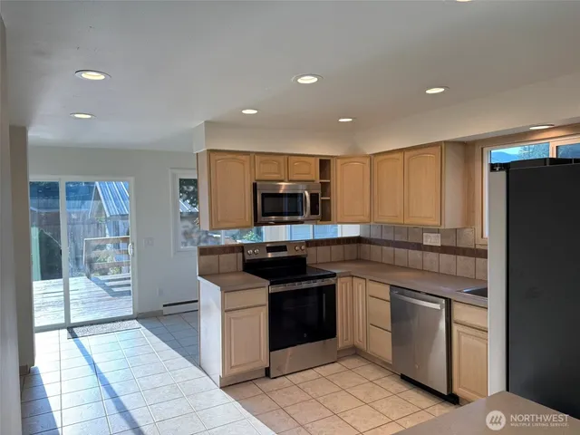 a kitchen with stainless steel appliances granite countertop a refrigerator and a sink
