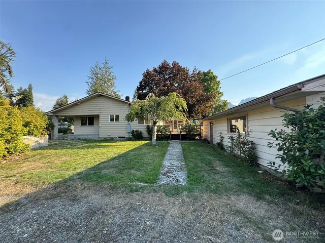 a front view of a house with a yard and trees