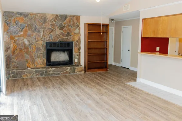 a view of empty room with wooden floor and fireplace