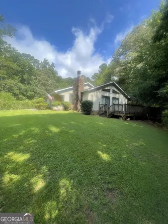 a view of a big house with a big yard and large trees
