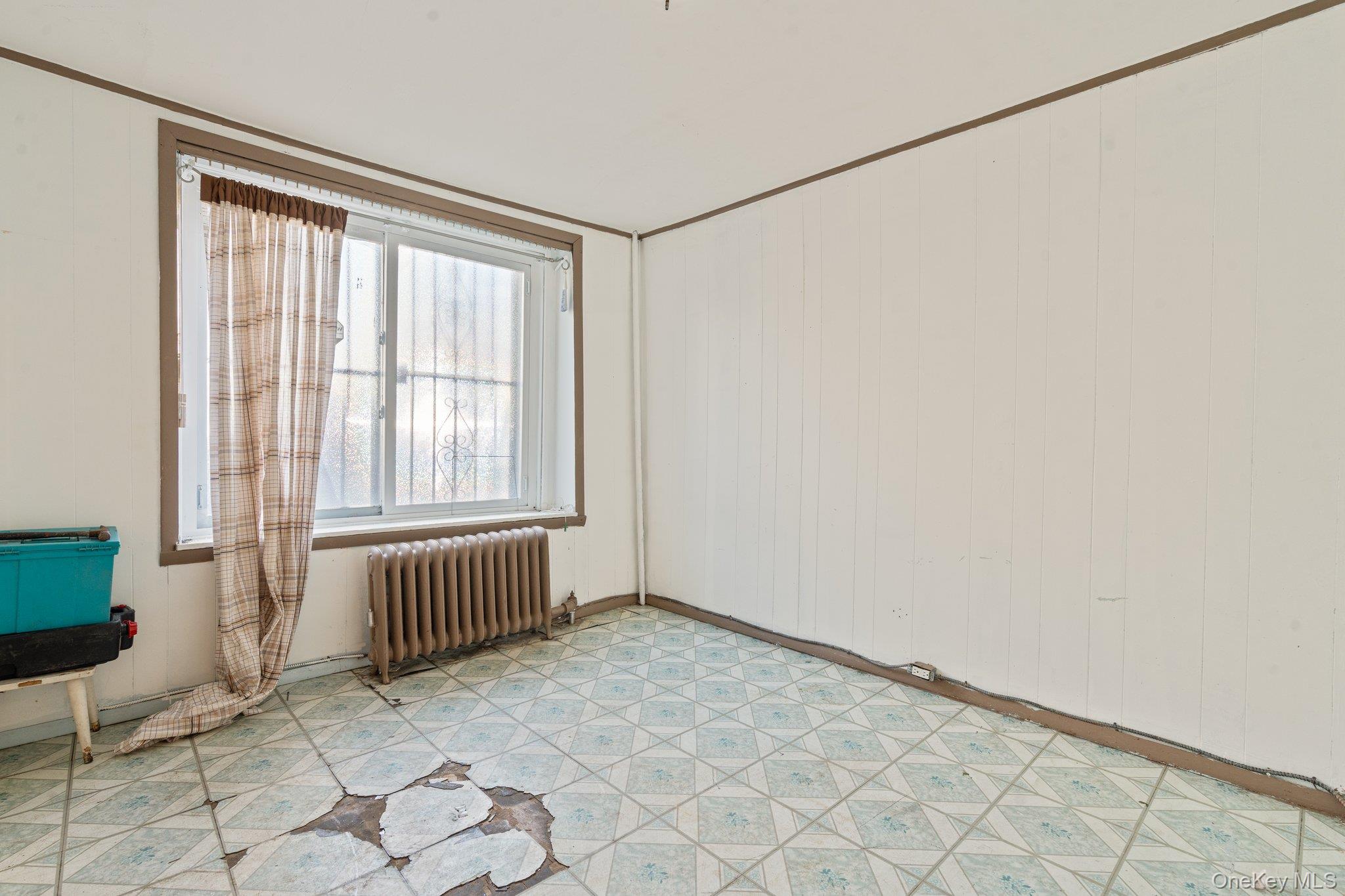 100-30 Martense Avenue Queens, NY 11368 - Photo 11 of 36 Empty room featuring radiator and light floors