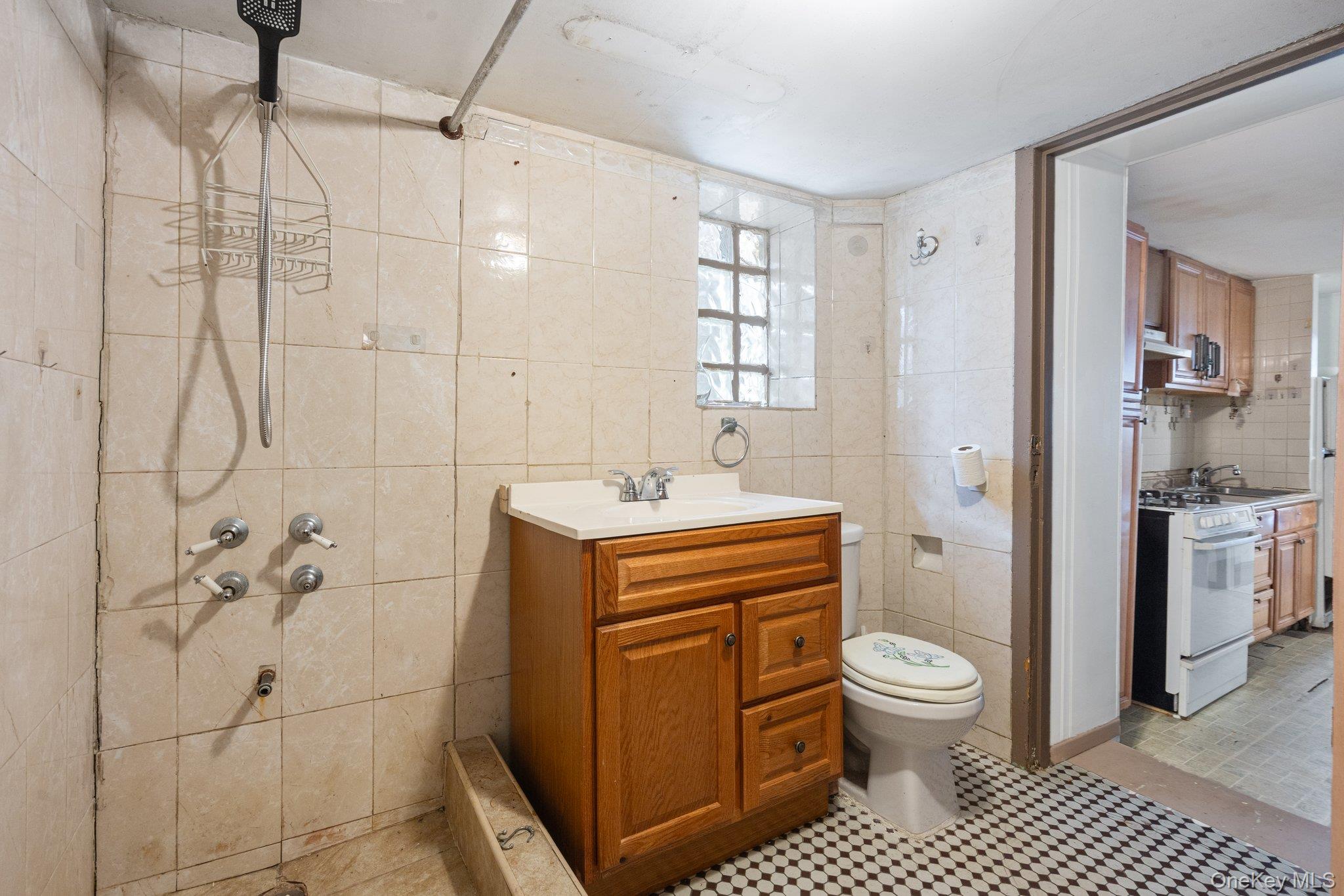 100-30 Martense Avenue Queens, NY 11368 - Photo 16 of 36 Bathroom with toilet, tile walls, a tile shower, and vanity