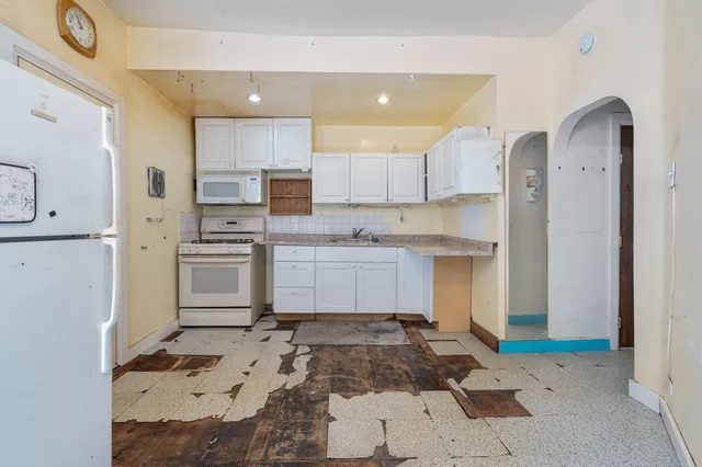 a kitchen with a refrigerator and a stove top oven