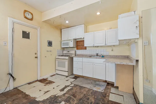 a kitchen with white cabinets and white appliances