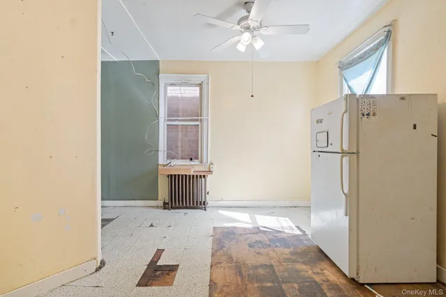 a view of a hallway with a refrigerator and window