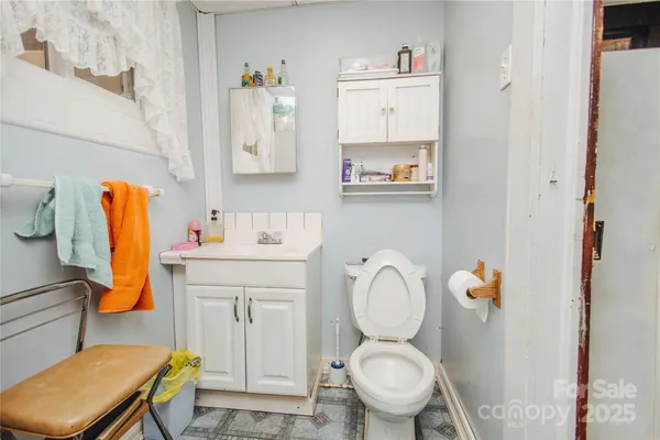 a bathroom with a sink toilet and painting on the wall