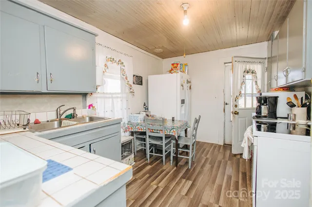 a kitchen with stainless steel appliances wooden floor dining table and chairs