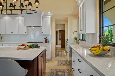 a kitchen with stainless steel appliances granite countertop a sink a stove and a refrigerator
