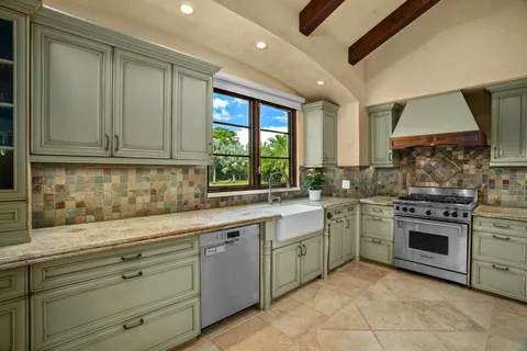 a kitchen with a stove sink and cabinets