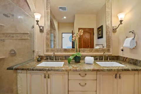a bathroom with a granite countertop sink and a mirror