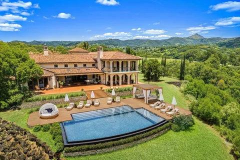 an aerial view of a house with swimming pool garden and mountain view
