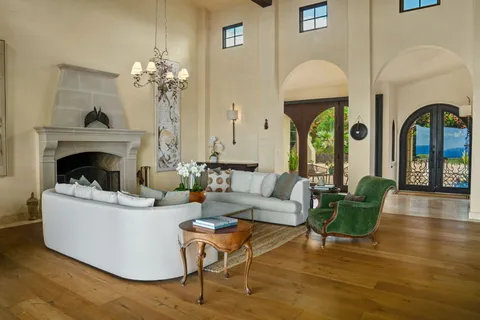 a living room with fireplace furniture and a chandelier